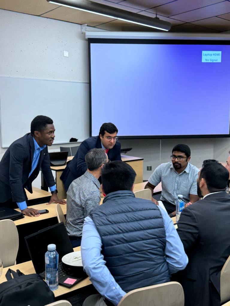 George Amoako and peers collaborating around desks at UNBC Investment Club