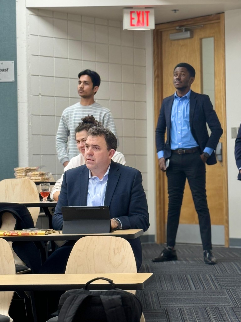 George Amoako standing during a UNBC Investment Club classroom meeting